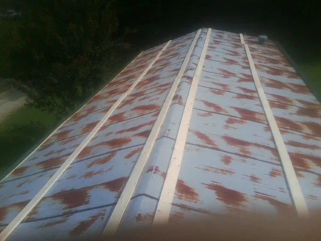 Rusted metal roof panels with new wood purlins before replacement — Storm Damage Roof Repair in Saint Leo by Roofing Brothers